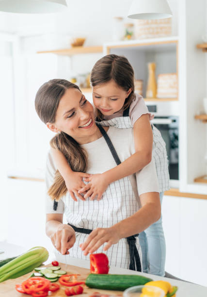 mãe e filha na cozinha - vegan food cheerful vertical indoors - fotografias e filmes do acervo