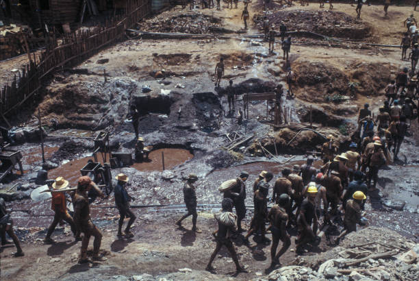 Pelada Mountain Mine Garimpeiros in Serra Pelada Gold Mine, a village near Curionópolis, Amazon, Pará State, Brazil. Serra Pelada was a large gold mine in Brazil in the 1980’s. Gold Rush, 1986. gold mining panning stock pictures, royalty-free photos & images
