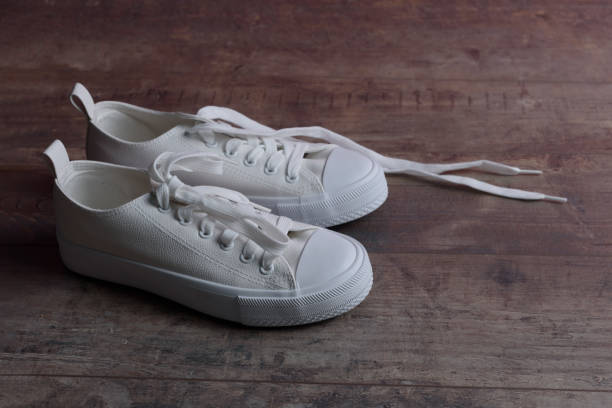 istock White sneakers for childrenon a old textured wood background 1393788559
