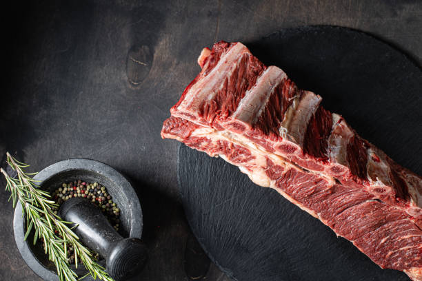 Fresh raw beef ribs meat on black background