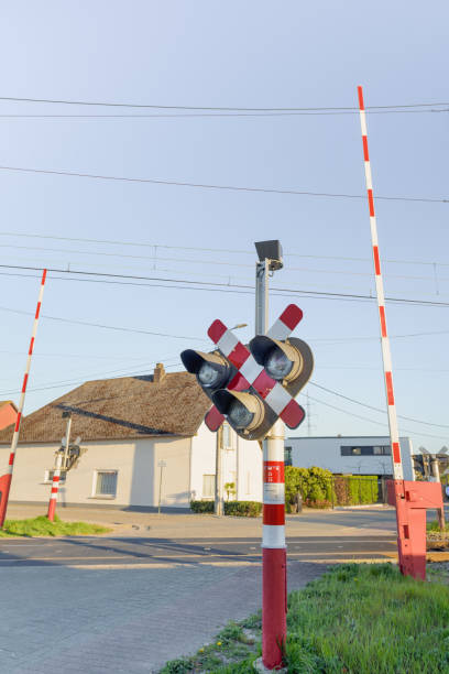 semaphore und barriere. bahnübergang. warnschild über die nähe eines bahnübergangs. seitenformat - railroad crossing train railroad track road sign stock-fotos und bilder