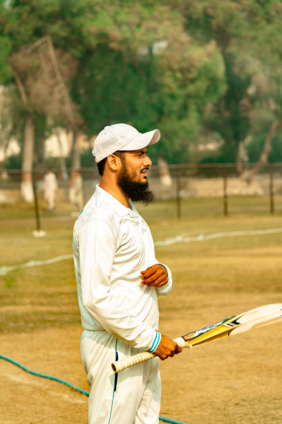 istock cricket player holding a bat in match ground 1393791789