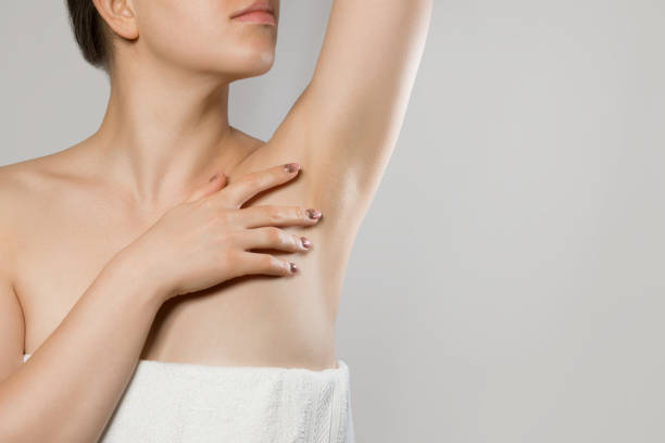 Armpit epilation, lacer hair removal. Young woman holding her arms up and showing clean underarms, depilati on smooth clear skin .Beauty portrait. Skin care. stock photo