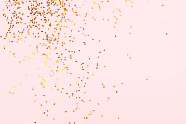 istock Golden confetti on pink background. 1393810431