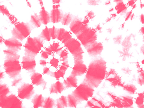 Tie dye shibori pattern. Abstract tie-dye technique hand dyed fabric. Red pink ornamental circles elements on white background. Abstract texture.