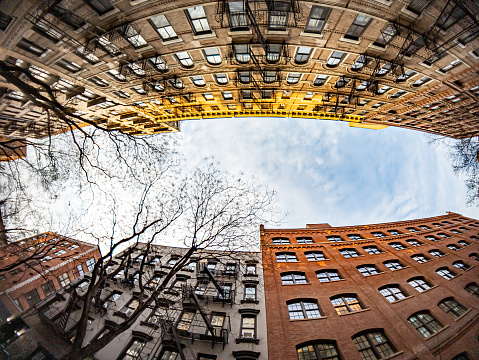 Looking up at a block of historic buildings in Manhattan New York City with fisheye lens effect