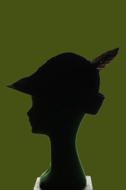 puppet head silhouette profile wearing alpin military hat with feather, green background, copy space