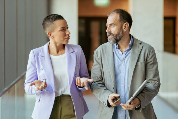 Business partners walking down in office building and talking