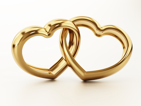 Linked heart shaped wedding rings isolated on white.