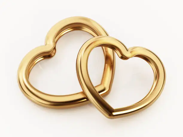 Photo of Linked heart shaped wedding rings isolated on white
