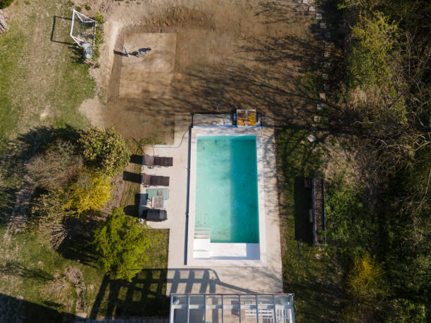 istock Drone flight over fresh earth area with grass grown next to pool 1393820146