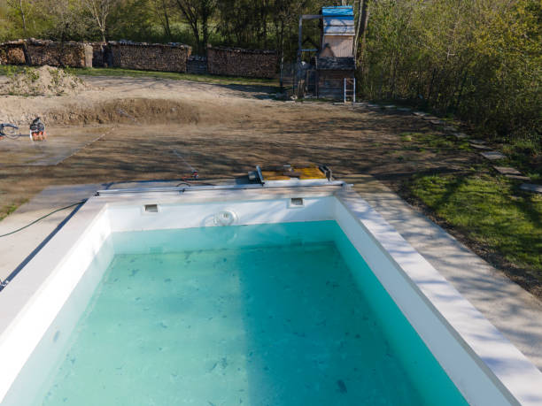 istock Drone flight over fresh earth area with grass grown next to pool 1393820148