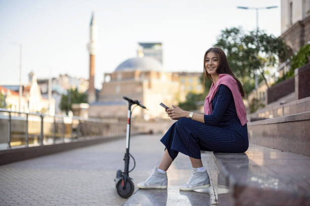 Woman with e-scooter in the city stock photo