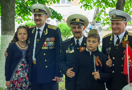 PYATIGORSK, RUSSIA - MAY 09, 2017: Children are photographed with veterans sailors in medals on a victory day