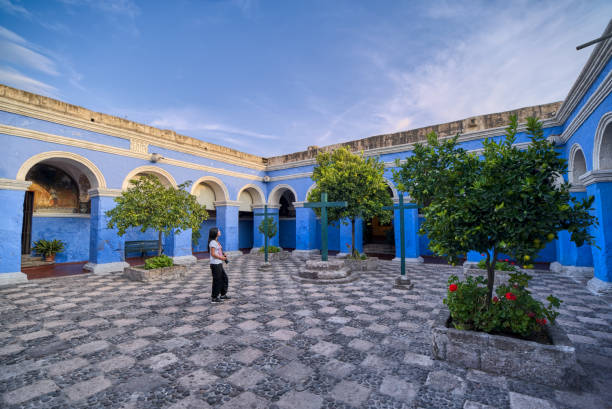 아레키파에있는 산타 카탈리나 수도원의 오렌지 나무 회랑을 감상하는 라틴 관광객 - peru arequipa monastery convent 뉴스 사진 이미지