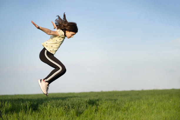A small girl is jumping high
