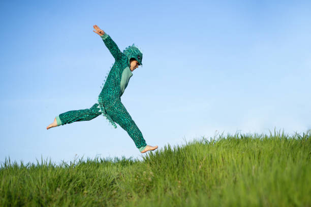 istock A boy in a dinosaur costume is jumping 1393824266