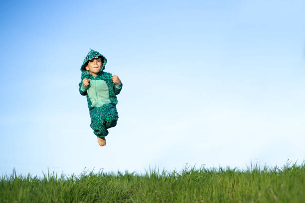 istock A boy in a dinosaur costume is jumping 1393824277