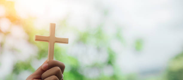 istock wooden cross on hand and religious ideas. 1393825189