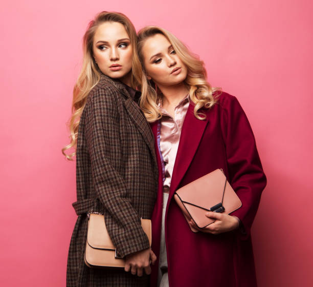 istock Two sweet young women posing in nice clothes, coat, handbag 1393826144