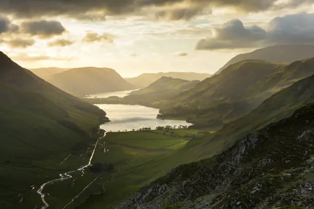 Dark and dramatic skies above Buttermere and Crummock Water with Summer sunlight shining into valley.