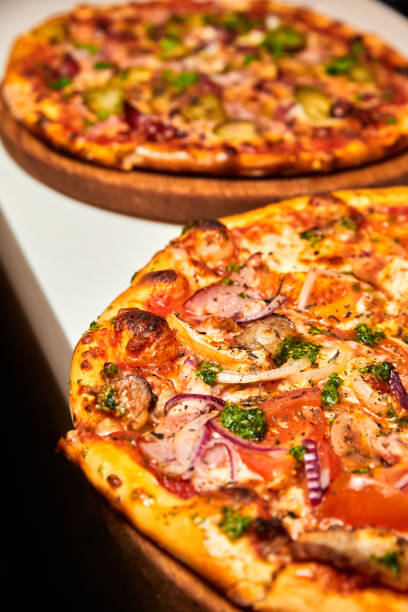 istock Fresh pizza with bacon, mushrooms and cheese on a light background. Close-up, selective focus 1393826514