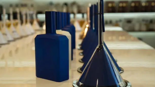 Photo of Perfume bottles and funnels with fragrance on the counter in a luxury store