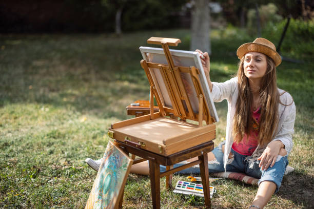 istock Girl painting outside 1393828571