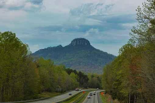 Pilot Mountain, North Carolina, USA ' April 13, 2022:  Captured through a windshield while traveling Highway 52, Pilot Mountain.