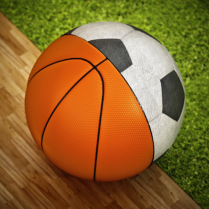 Portrait of young charming player holding basketball ball while standing against plain background