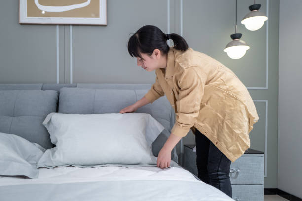 istock An Asian woman is making her bed at home 1393829107