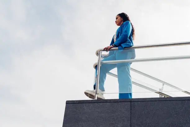 Photo of Young businesswoman, on top of a skyscraper looking at the horizon. Concept of feminism, success, strength, businesswoman, new generations, tenacity and courage. copy space