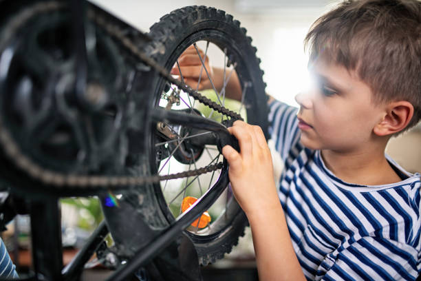 istock Little boy repairing a bicycle at home 1393834813