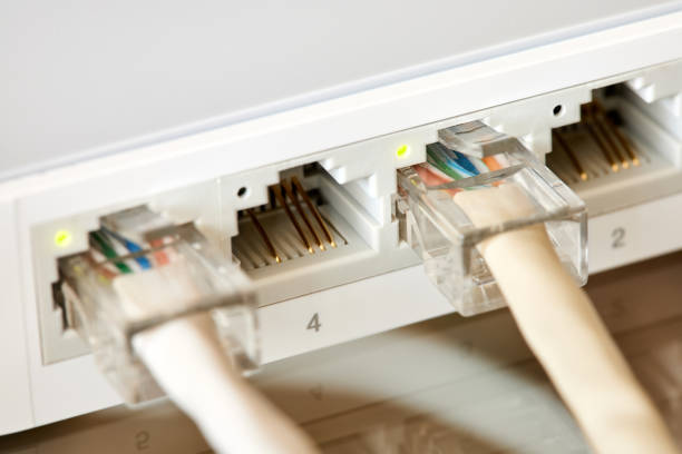 istock Ethernet cables connected to Desktop Switch or routerboard. Close-up, selective focus 1393835679