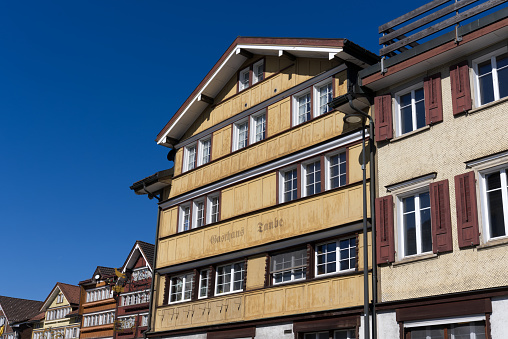 Facades of historic houses at village of Urnäsch on a sunny spring day. Photo taken April 19th, 2022, Urnäsch, Canton Appenzell Ausserrhoden, Switzerland.