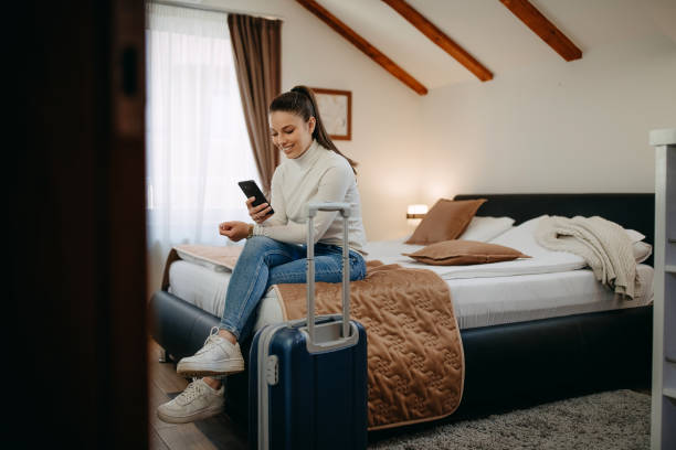 istock Woman text messaging on a cellphone in her hotel room 1393838578