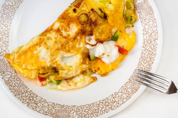 istock Egg omelette stuffed with onion, red pepper,avocado and yoghurt on plate, fork. 1393844769