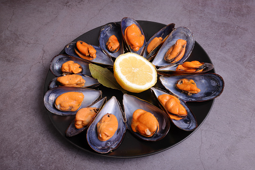 Ration of mussels from the Galician estuary cooked with lemon and bay leaf garnish.
