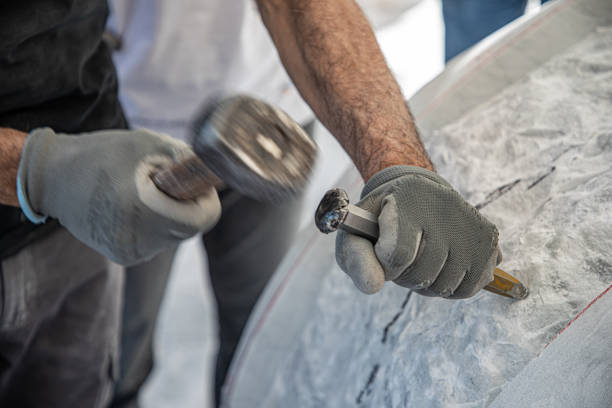istock Hands of artist who work the marble with hammer and chisel 1393847581