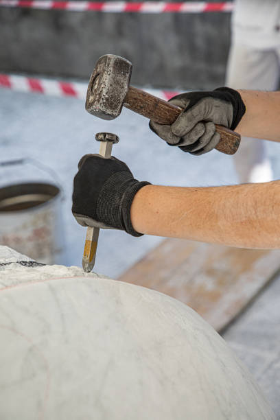 Hands of artist who work the marble with hammer and chisel stock photo