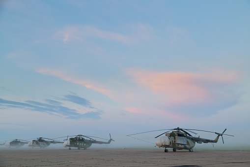 Military helicopters MI-8 at the airfield in the early morning before dawn