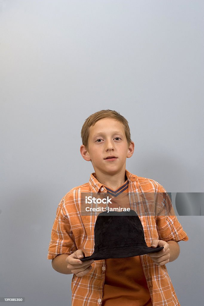 My Hat A young boy holding his hat in his hands with room for copy above him. Boys Stock Photo