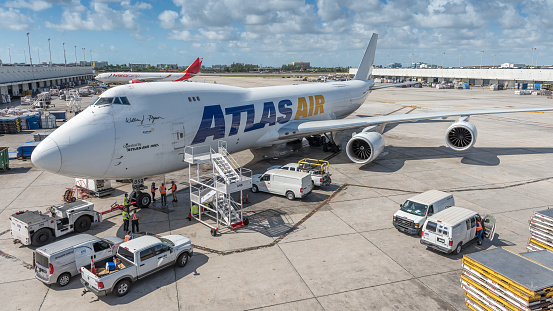 Miami, United States - April 25, 2022: Cargo planes at Miami International Airport, ready to transport goods around the world. In the foreground the cargo airline Atlas Air. Atlas Air is the world's largest operator of the Boeing 747 aircraft, with a total fleet of 54 of this specific fleet type.