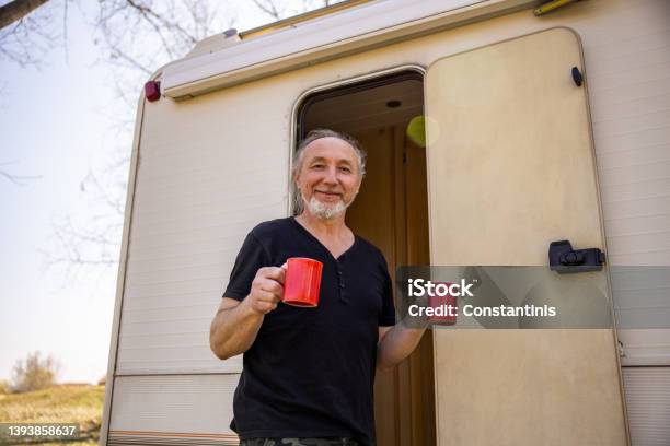Carefree Man Holding Cup Of Coffee During Picnic Time With Hic Camper Van Stock Photo - Download Image Now