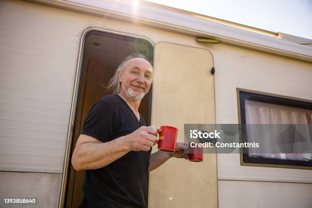 Joyful Man Holding Cup Of Coffee During Picnic Time With Hic Camper Van Stock Photo - Download Image Now