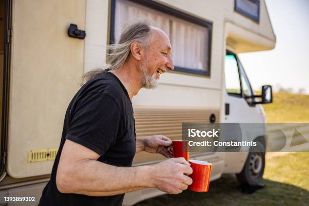 Serene Man Holding Cup Of Coffee During Picnic Time With Hic Camper Van Stock Photo - Download Image Now