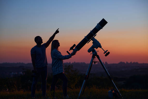 istock Couple stargazing together with a astronomical telescope. 1393859716