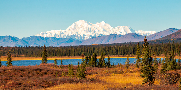 Alaska's Denali Mountain and its reflection on a blue colored lake on a clear autumn day.