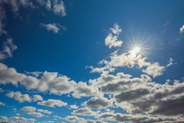 Beautiful view of sun breaking through blue cloudy sky.