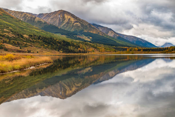 istock dramatic sky and autumn foliage and mounter reflection on a tranquil lake in Kenai peninsula , Alaska 1393862801